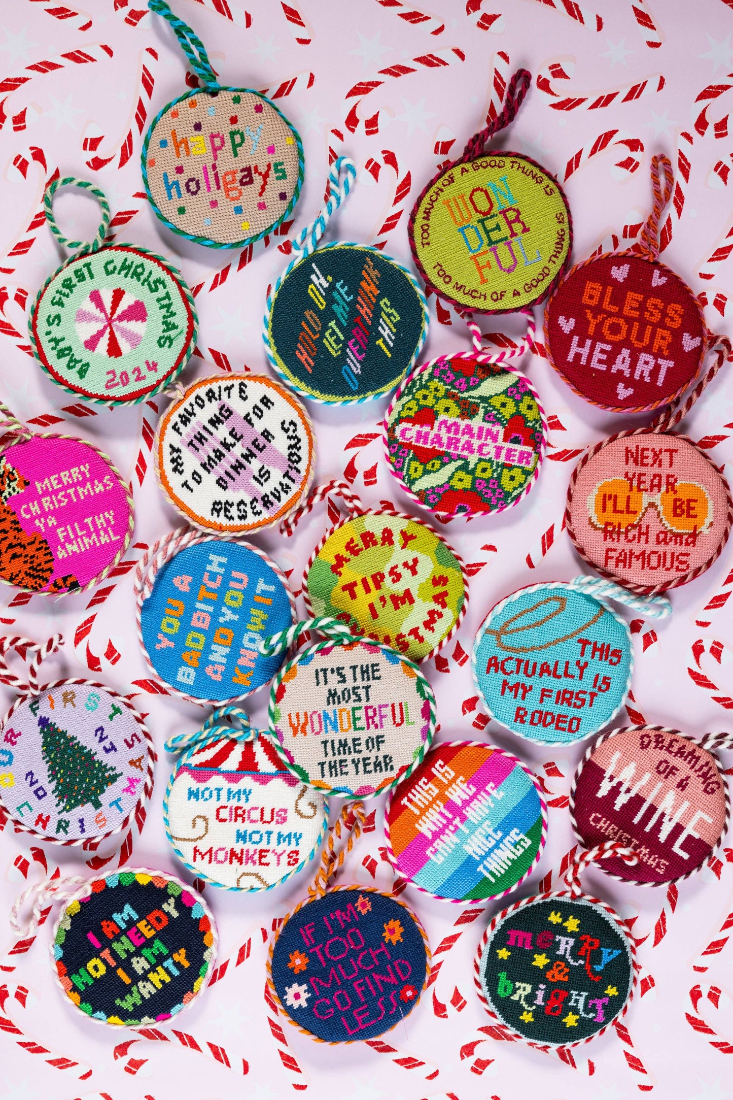 Colorful Christmas ornaments with various messages on a red and white striped background