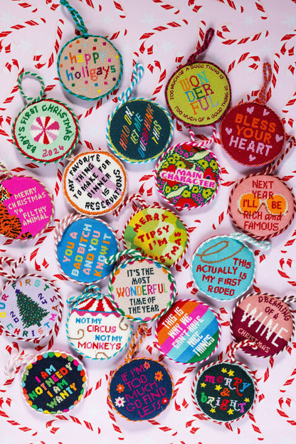 Colorful Christmas ornaments with various messages on a red and white striped background