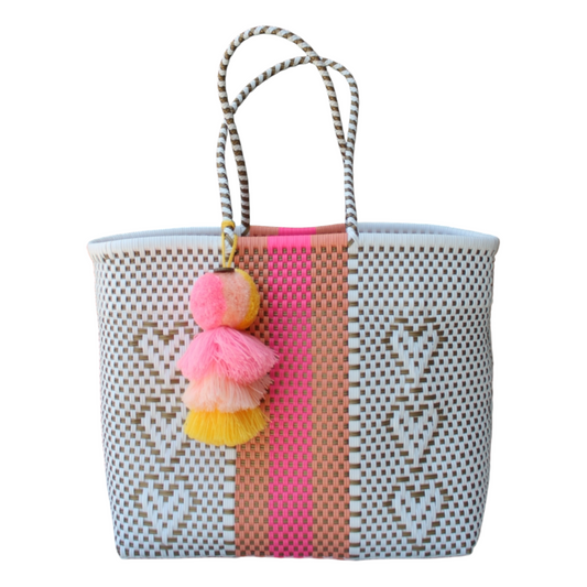 Colorful woven bag with pom-pom details on a white background