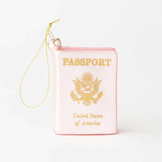Pink passport-shaped pouch with gold text and design on a white background