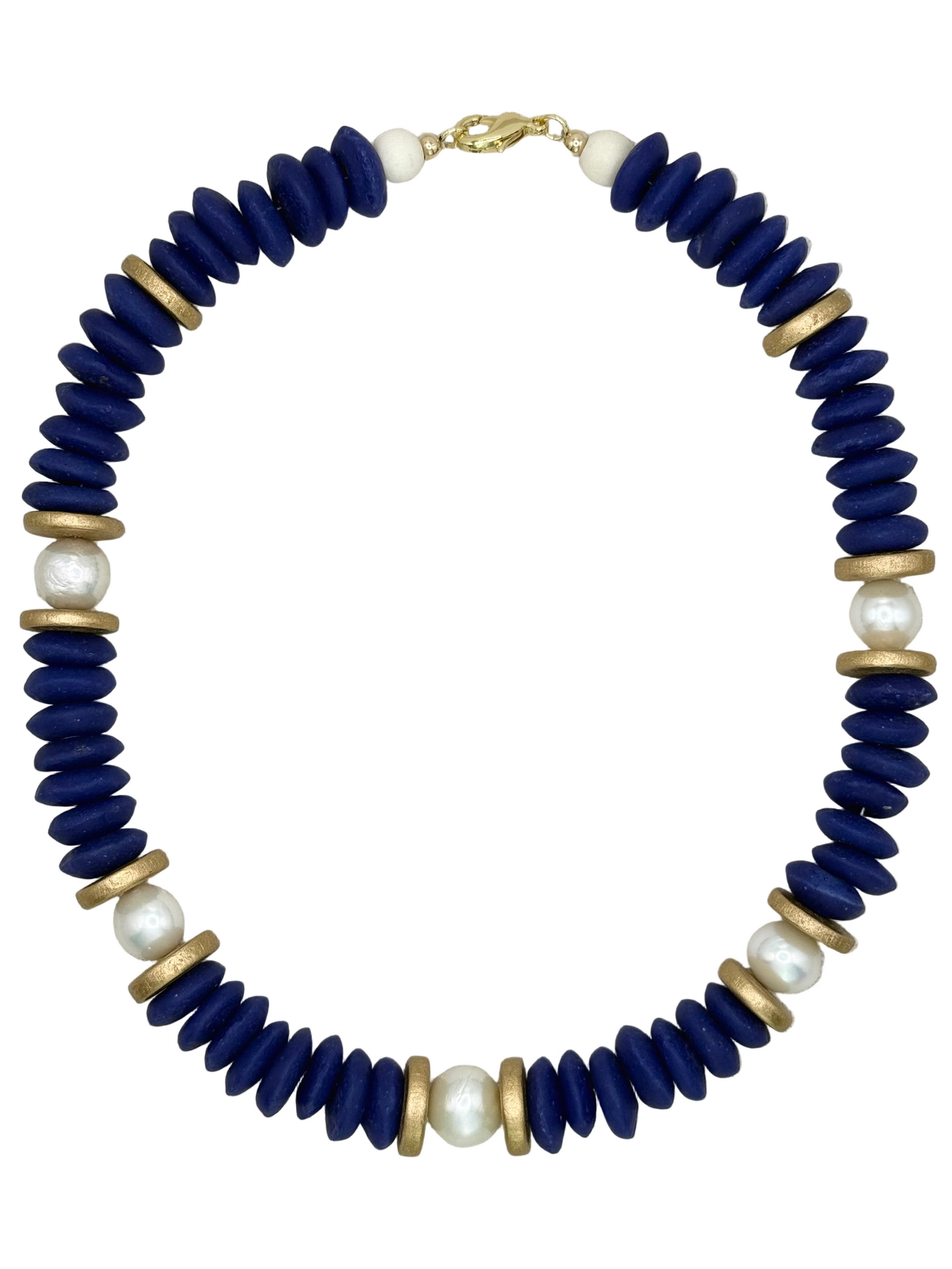 Necklace with blue beads, gold accents, and pearls on a beige fabric background