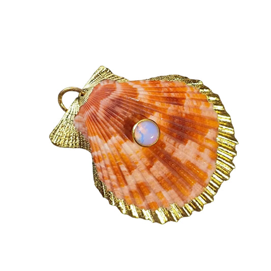 Shell-shaped pendant with a gold outline and central gemstone on a black background