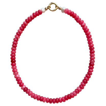 pink beaded bracelet with a gold clasp on a beige fabric background
